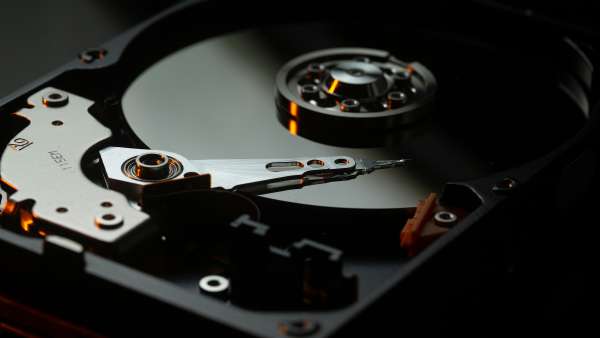 The platter and read/write arm inside an exposed hard disk drive.